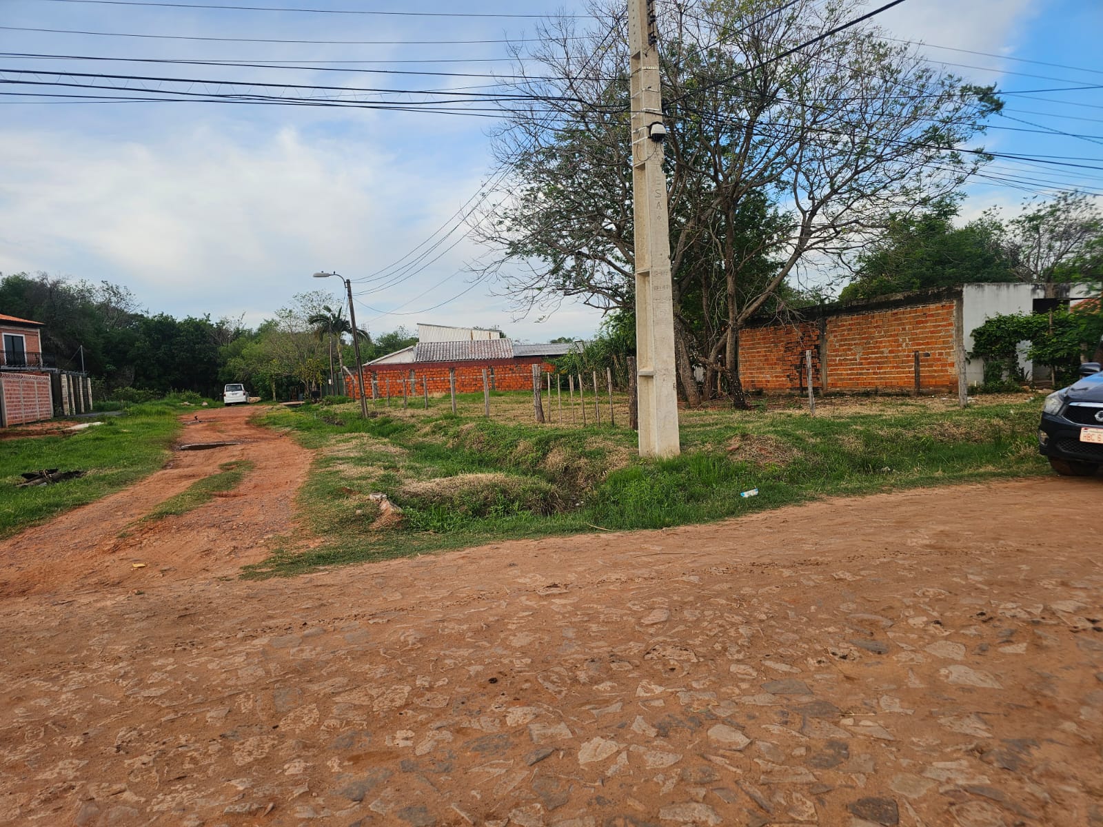 Esquina del terreno vista desde la calle, con la columna de luz y el cruce de calles